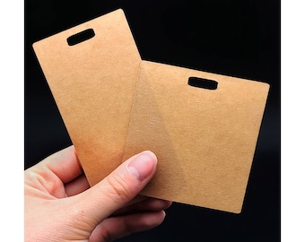 May include: Two brown cardboard tags with a hole punched in the top center of each tag.
