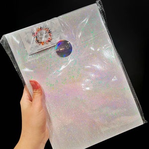 May include: A sheet of iridescent white glitter paper with a small sticker that says "Beautifully Crafted" on it.