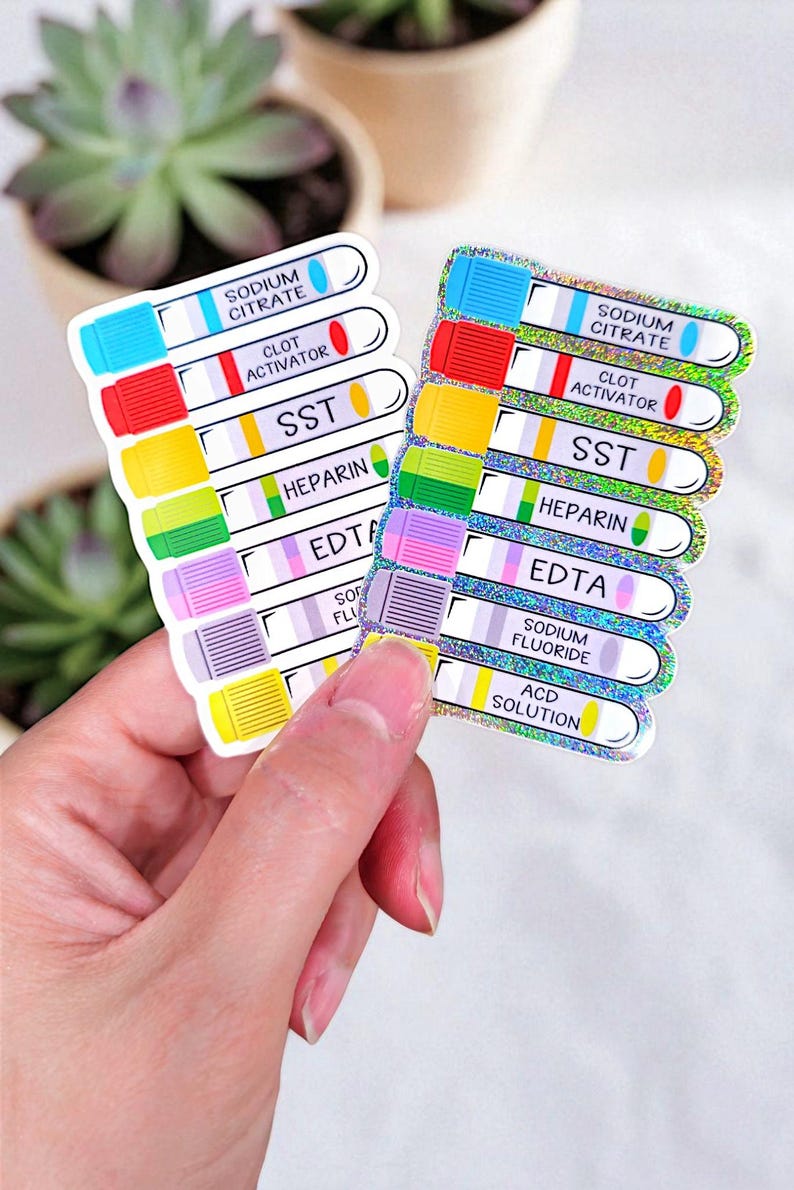 Op de afbeelding: Twee stickervellen met kleurrijke ontwerpen van bloedafnamebuizen. Elke buis heeft een dop en een etiket in een andere kleur met tekst als "Sodium Citrate", "Clot Activator" en "SST". De stickers worden in een hand gehouden.