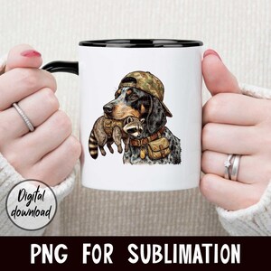 May include: White ceramic mug with a black handle and rim. The mug features a detailed illustration of a dog wearing a camouflage hat and carrying a raccoon. The words "Digital download" are on the left side of the mug. The words "PNG FOR SUBLIMATION" are at the bottom.