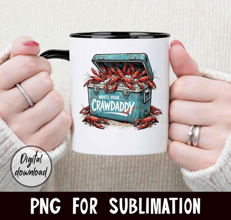 Puede incluir: Taza de cer&aacute;mica blanca con asa y borde negros. La taza presenta un gr&aacute;fico de nevera azul llena de cangrejos rojos y el texto "Who's your Crawdaddy". Tambi&eacute;n son visibles las palabras "Digital download".