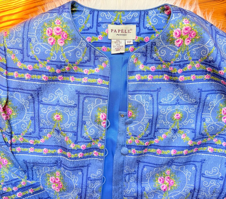 Puede incluir: Una chaqueta azul y rosa con estampado floral y cierre de bot&oacute;n. La etiqueta dice "Papell Petite" y "Talla 4 Petite, Hecho en China".