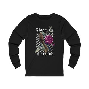 Puede incluir: Camiseta negra de manga larga con un gráfico de un pájaro posado en una rosa con el texto "Throw me tf around" en una fuente gótica.