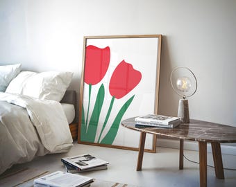 May include: A framed print of two red tulips with green stems and leaves on a white background. The print is hanging on a white wall above a brown marble coffee table with a lamp.
