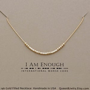 Unique Jewelry for women, Dainty gold filled necklace with beads that spell out the message 'I AM Enough' in morse code. '14k Gold Filled Necklace', 'Handmade in USA', and 'QueenBJwlry.Etsy.com'.