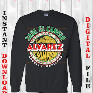 May include: A black sweatshirt with a graphic design of a red, yellow, green, and white circle with the text "SAUL EL CANELO ALVAREZ CHAMPION ORGULLO MEXICANO" inside the circle.