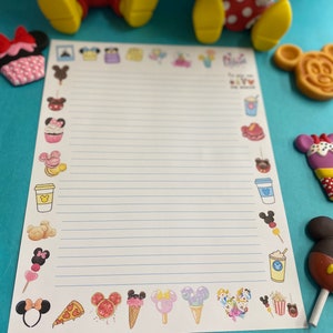May include: A white sheet of paper with blue lines and a border of colorful cartoon images of Mickey Mouse and Minnie Mouse themed food and drinks. The paper is on a blue surface.