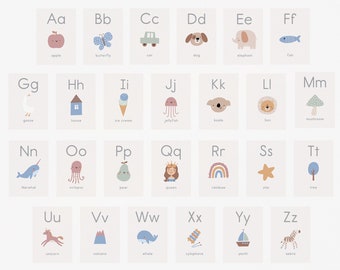 May include: A set of alphabet flashcards with illustrations of animals, objects, and food. Each card features a letter in a light blue font and a corresponding image. The cards are displayed on a white wall above a pink crib.