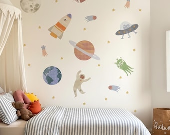 May include: A child's bedroom with space-themed wall decals. The decals include a moon, planets, rockets, an astronaut, and stars. The bed has a striped comforter and pillows. A brown teddy bear and decorative pillows are on the bed.