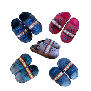 May include: Six pairs of patterned indoor slippers in various colors, including blue, red, and brown. The slippers have a geometric design and are made of soft, comfortable fabric.