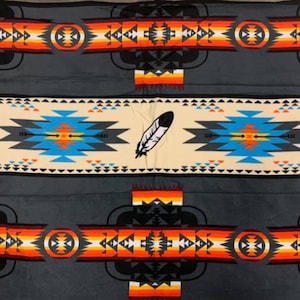 Puede incluir: Una tela gris con un patrón repetitivo de diseños inspirados en los nativos americanos. El patrón presenta colores naranja, rojo, amarillo, azul y negro. El diseño incluye plumas, flechas y formas geométricas.