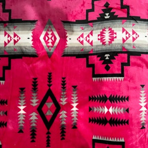 May include: Pink fabric with a black, white, and gray geometric pattern. The pattern is reminiscent of Native American designs.