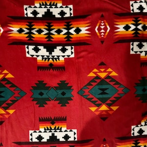 May include: Red fabric with a geometric pattern in black, white, yellow, orange, and green. The pattern is reminiscent of Native American designs.