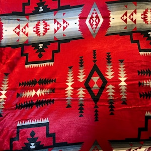 May include: Red, black, and gray patterned fleece blanket with a Native American inspired design.