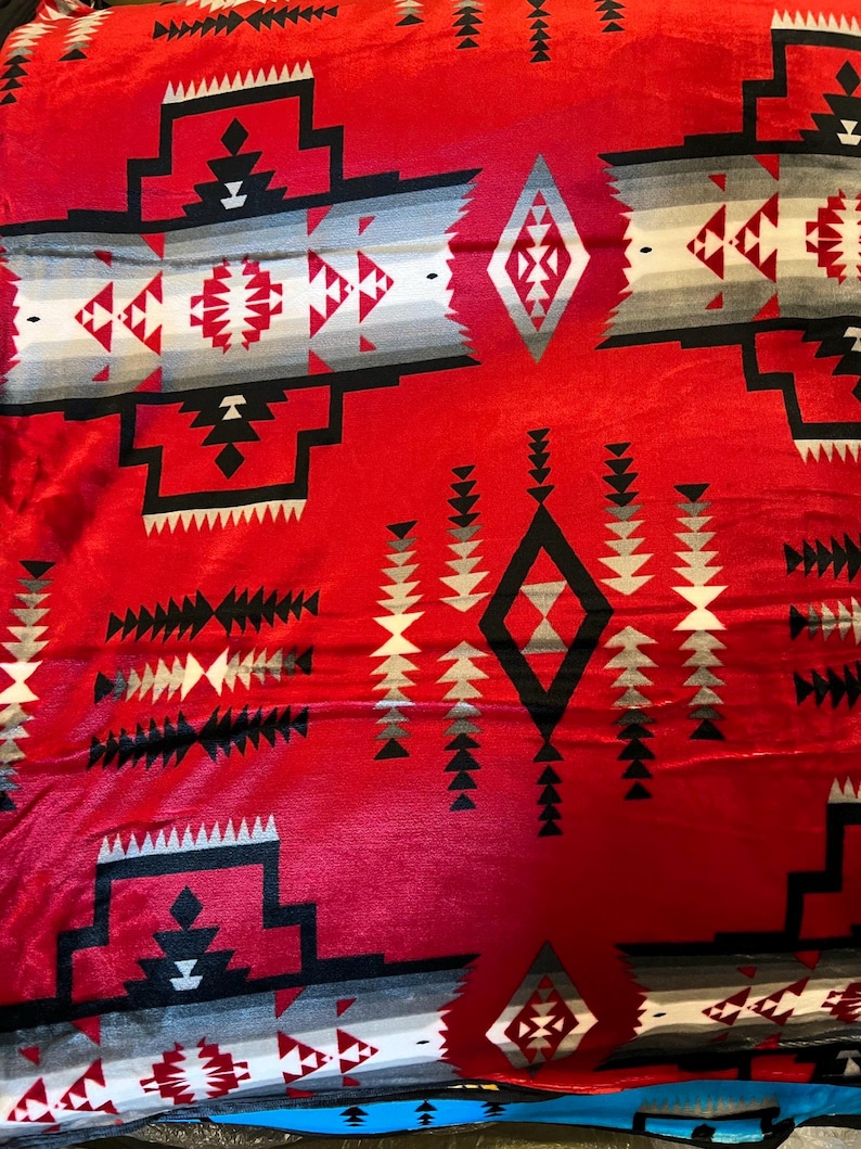 May include: Red, black, and gray patterned fleece blanket with a Native American inspired design.