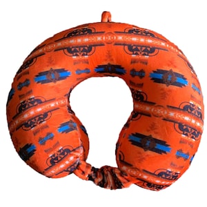 May include: Orange travel neck pillow with a geometric pattern in shades of blue, brown, and white.