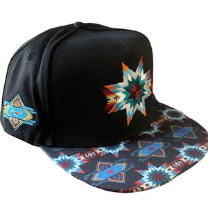 Puede incluir: Gorra de béisbol negra con un diseño de estrella bordada colorida en la parte delantera y un patrón geométrico en la visera. La gorra también presenta un diseño bordado más pequeño en el lateral. Un accesorio elegante.