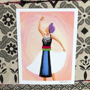 K&ouml;nnte beinhalten: Ein Gem&auml;lde einer Frau in einem wei&szlig;en, blauen, gr&uuml;nen und roten Kleid mit einem violetten Kopftuch, die vor einem rosa und wei&szlig;en Hintergrund tanzt.