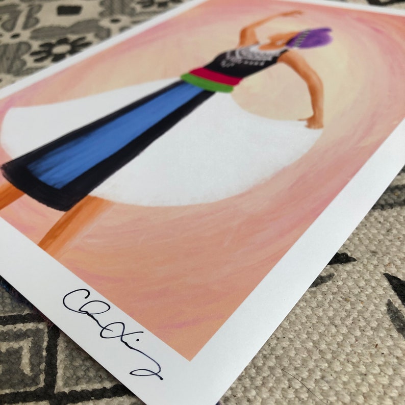 K&ouml;nnte beinhalten: Eine farbenfrohe Illustration einer Person, die ein wei&szlig;es Kleid mit einem blauen und schwarzen Rock, einem roten und gr&uuml;nen G&uuml;rtel und einem violetten Kopfschmuck tr&auml;gt. Die Person tanzt mit erhobenen Armen. Der Hintergrund ist zartrosa und orange.