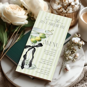 May include: A menu card with a martini illustration, black ribbon, and text that reads "Samantha's 21st Birthday" and "MENU". The card is light green with vertical stripes. The menu lists entree, main, and dessert options.