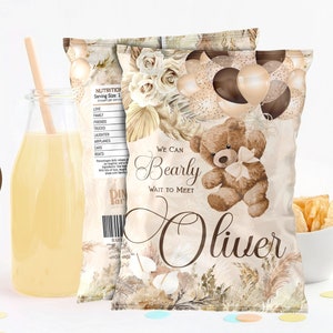 May include: A brown chip bag with a teddy bear holding balloons. The bag has a watercolor design with gold accents and the text "We can Bearly wait to meet Oliver".