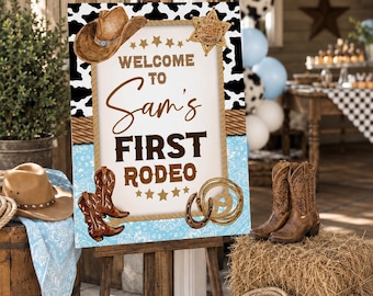 Może przedstawiać: Drewniany sztalug prezentuje znak z napisem "Welcome to Sam's First Rodeo". Znak zawiera kapelusz kowbojski, buty i odznakę szeryfa. Tło obejmuje nadruk krowy i jasnoniebieski wzór paisley. Widoczny jest również kapelusz kowbojski i buty.
