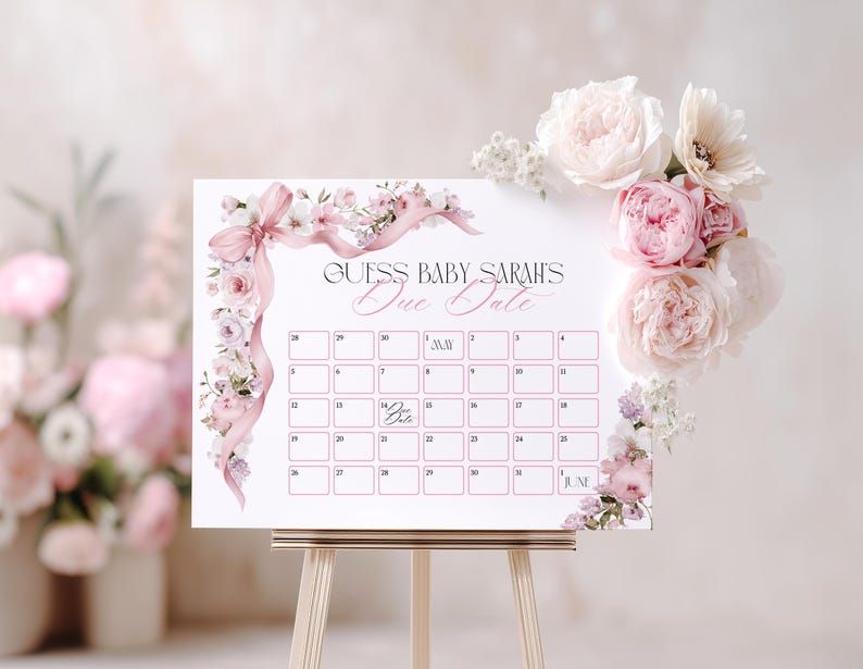 May include: A white baby shower calendar with the text "Guess Baby Sarah's Due Date" in elegant script. The calendar is decorated with pink floral accents and a pink ribbon. A bouquet of pink and white flowers adorns the top right corner.