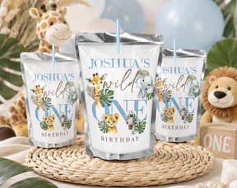 Puede incluir: Tres bolsas de bebida de aluminio plateado con pajitas azul claro, cada una con ilustraciones de jirafa, elefante, león y cebra, hojas tropicales verdes y el texto JOSHUA'S wild ONE BIRTHDAY impreso en azul y marrón en la parte frontal.