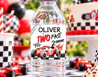 May include: A clear plastic water bottle with a red cap and a custom label featuring a red race car, a checkered flag, and the text Oliver is TWO FAST 2 CURIOUS. The label includes a tire track graphic and a black and white checkered border.