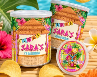 May include: Two cylindrical chip containers with lids, decorated with a tropical theme, featuring a thatched roof design and the text "Sara's 7th Wau Birthday". Several potato chips and tropical flowers are scattered around the containers.