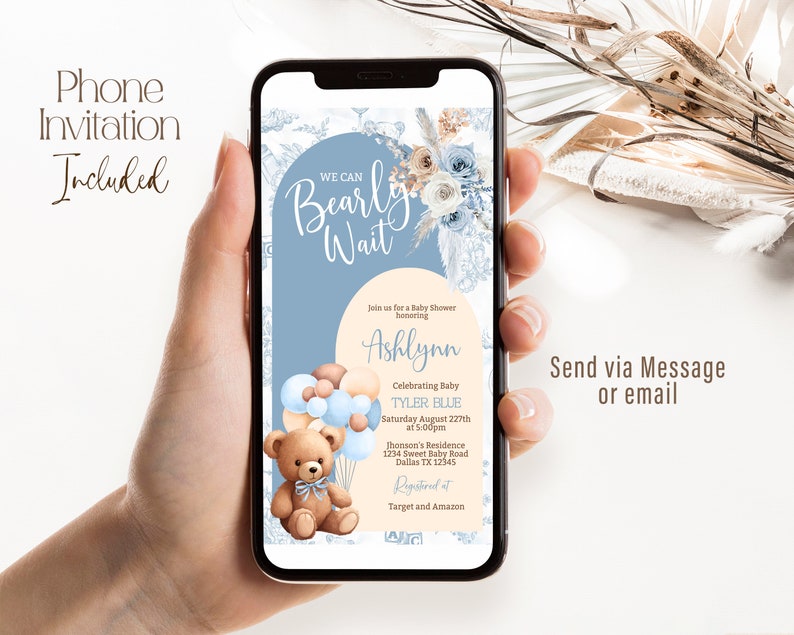 May include: A blue and white phone screen with a baby shower invitation. The invitation features a teddy bear holding balloons, a floral design, and the text "We Can Bearly Wait". The invitation is for a baby shower honoring Ashlynn and celebrating baby Tyler Blue. The shower will be held on Saturday, August 22nd at 5:00pm at Jhonson's Residence, 1234 Sweet Baby Road, Dallas TX 12345. The invitation also includes information about where to register for gifts: Target and Amazon.