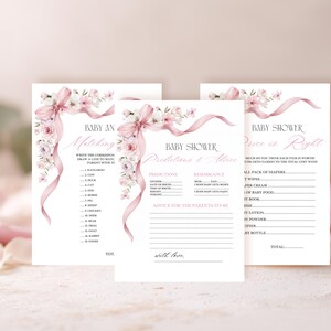 May include: Three baby shower game cards with floral and ribbon details. The cards feature games like "Baby An Matching" and "Price is Right". The design includes pink and white flowers and ribbons, with text in a delicate script font.