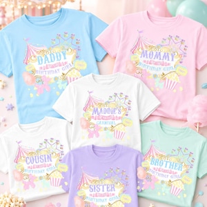 May include: A collection of pastel-colored t-shirts with carnival-themed graphics. Each shirt features a different title: "Daddy," "Mommy," "Cousin," "Sister," and "Brother," along with "Birthday Girl." The shirts have a Ferris wheel, tent, and cotton candy design.