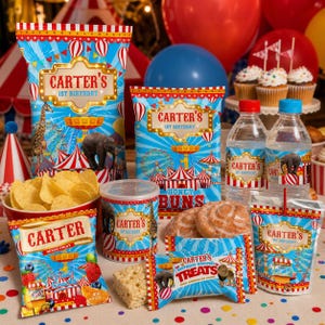 K&ouml;nnte beinhalten: Eine festliche Geburtstagsparty mit verschiedenen Snacks und Getr&auml;nken. Die Verpackung ist mit einem Zirkus-Thema gestaltet, einschlie&szlig;lich Elefanten, Giraffen und einem Riesenrad. Der Text "CARTER'S 1ST BIRTHDAY" ist deutlich sichtbar.