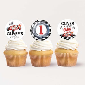 Può includere: Tre cupcake bianchi con decorazioni a tema auto da corsa rosse, nere e bianche. Le decorazioni dicono "Oliver's First Birthday" e "Oliver is a Fast One".