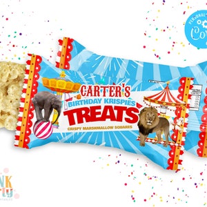 K&ouml;nnte beinhalten: Zwei blau-wei&szlig;e T&uuml;ten mit Zirkusmotiven, darunter ein Elefant auf einem Ball und ein L&ouml;we. Die T&uuml;ten sind mit "Carter's Birthday Krispies Treats Crispy Marshmallow Squares" beschriftet.
