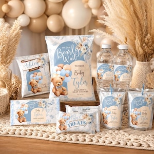Może przedstawiać: Artykuły na baby shower z motywem misia. Artykuły obejmują torby na przekąski, butelki z wodą i torby na smakołyki z napisem "Bearly Wait to Meet Baby Tyler". Schemat kolorów to jasnoniebieski, beżowy i biały.
