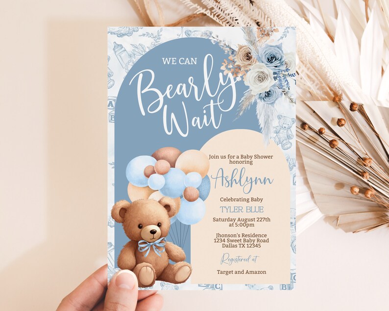 May include: A blue and brown baby shower invitation with a teddy bear holding balloons. The invitation says "We can Bearly Wait" and includes the name Ashlynn and the baby's name Tyler Blue. The invitation also includes the date, time, and location of the shower. It says "Registered at Target and Amazon".