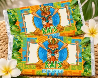 May include: Two chocolate bar wrappers with a tropical theme. Each wrapper features a blue tiki design with the name "Kai's" and the text "9th Luau Birthday!" in a colorful, festive design. The background includes green leaves and flowers.