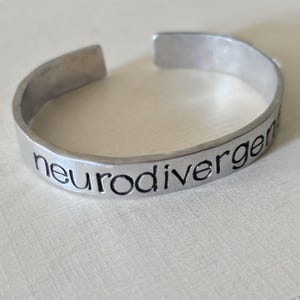 Pulsera neurodivergente - Brazalete de metal estampado hecho a mano