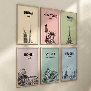 May include: Set of six framed prints featuring iconic landmarks from around the world. Each print has a different color background and features a black and white illustration of a famous landmark. The prints include: Dubai, New York, Paris, Rome, Sydney, and Prague.