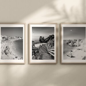 Pode incluir: Tr&ecirc;s fotografias a preto e branco emolduradas de uma cena de praia. A primeira fotografia mostra uma praia com uma cidade no fundo. A segunda fotografia mostra uma passarela de madeira que leva a uma praia com penhascos no fundo. A terceira fotografia mostra uma praia com penhascos e uma sali&ecirc;ncia rochosa em primeiro plano.