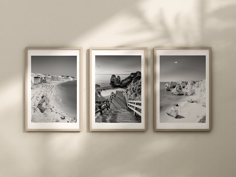 Pode incluir: Tr&ecirc;s fotografias a preto e branco emolduradas de uma cena de praia. A primeira fotografia mostra uma praia com uma cidade no fundo. A segunda fotografia mostra uma passarela de madeira que leva a uma praia com penhascos no fundo. A terceira fotografia mostra uma praia com penhascos e uma sali&ecirc;ncia rochosa em primeiro plano.