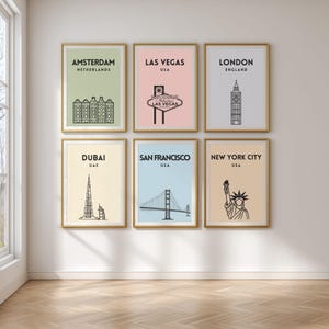 Peut inclure: Six affiches encadrées représentant des destinations de voyage. Les affiches présentent Amsterdam, Las Vegas, Londres, Dubaï, San Francisco et New York City. Chaque affiche a un cadre doré et un design minimaliste avec du texte.