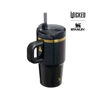 Op de afbeelding: Zwarte en gouden ge&iuml;soleerde beker met een handvat en een rietje. Op de beker staat het woord "WICKED" gedrukt, samen met het Stanley-logo. Een gouden accentband loopt rond de bovenkant van de beker.