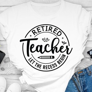 Op de afbeelding: Wit T-shirt met een zwart cirkelvormig ontwerp met de tekst "Gepensioneerde leraar Laat de pauze beginnen".