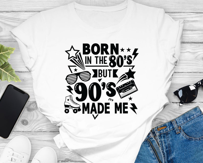 May include: White t-shirt with a black graphic design that says "Born in the 80's but 90's made me". The graphic includes a star, a lightning bolt, roller skates, sunglasses, and a cassette tape.