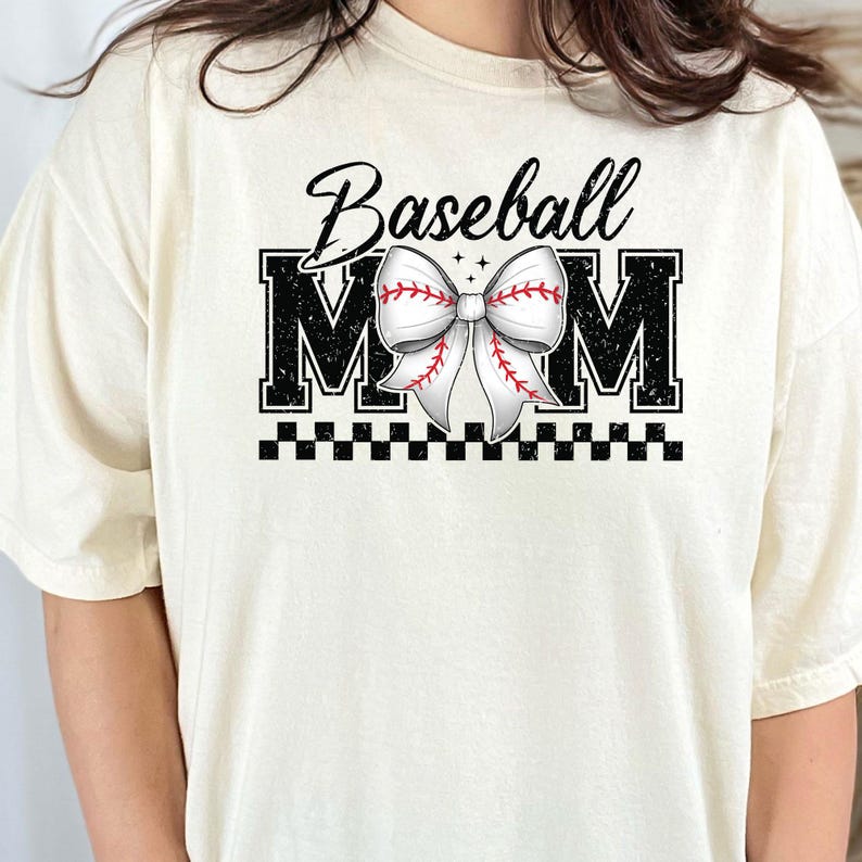 K&ouml;nnte beinhalten: Ein wei&szlig;es T-Shirt mit einer schwarz-wei&szlig;en Grafik, auf der "Baseball Mom" steht, mit einer Baseball-Schleife in der Mitte.