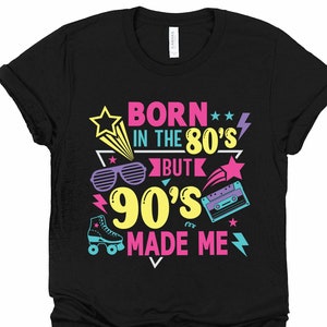 May include: Black t-shirt with a graphic design that says "Born in the 80's but the 90's made me". The graphic includes a retro cassette tape, sunglasses, and stars.