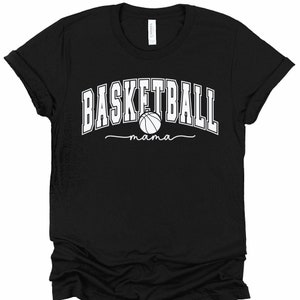 May include: Black t-shirt with white text that reads "Basketball mama" with a basketball graphic.